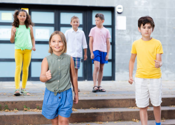 istock Positive tweenagers walking outside school building 1351307486