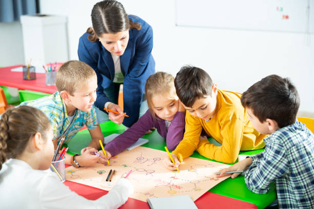 istock Kids with teacher playing educational tabletop game 1351309309