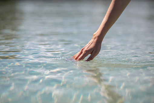 Close-Up Woman Hand Touching Water in Sea