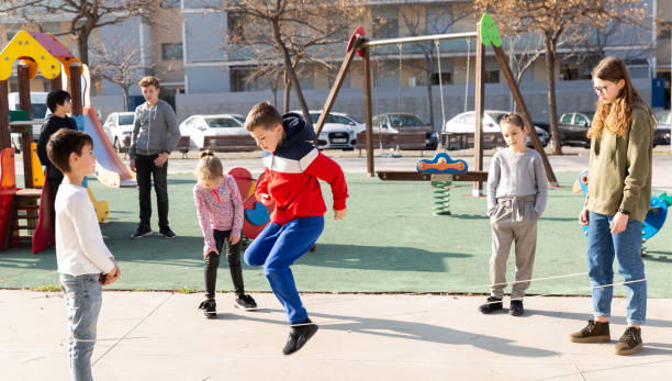 istock Children skipping on elastic jump rope 1351310518