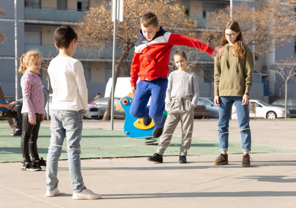 istock Children skipping on elastic jump rope 1351310561