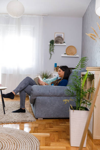 istock Young woman enjoying reading a book and relaxing 1351311498