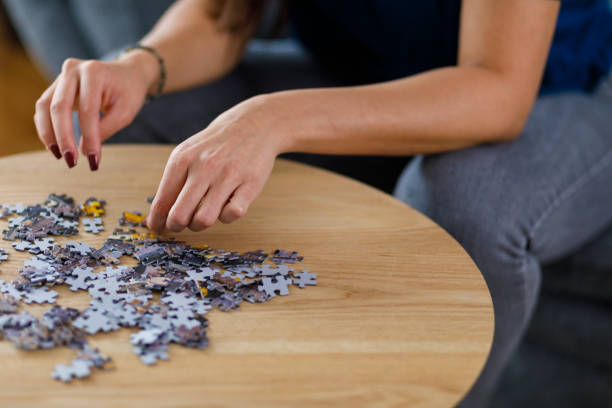 istock Woman solving jigsaw puzzle as entertainment 1351311803