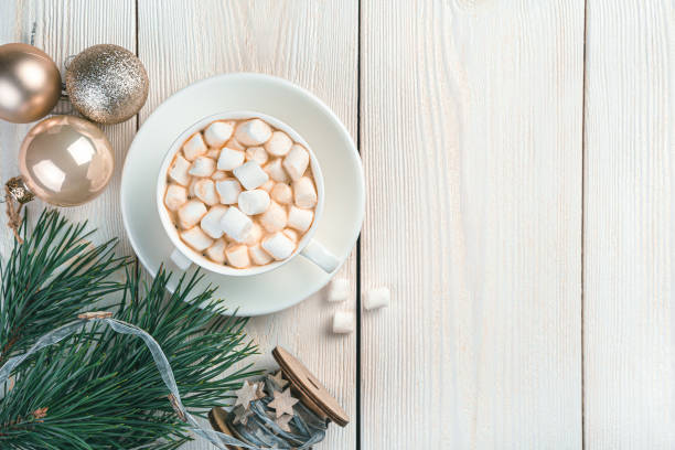 istock A cup with marshmallows, Christmas balls and pine branches on a light background 1351314865