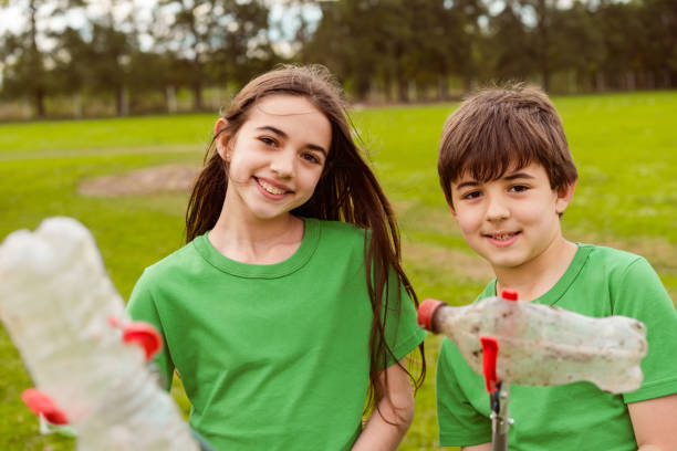 Brother embracing his smiling sister while they standing in front of green background