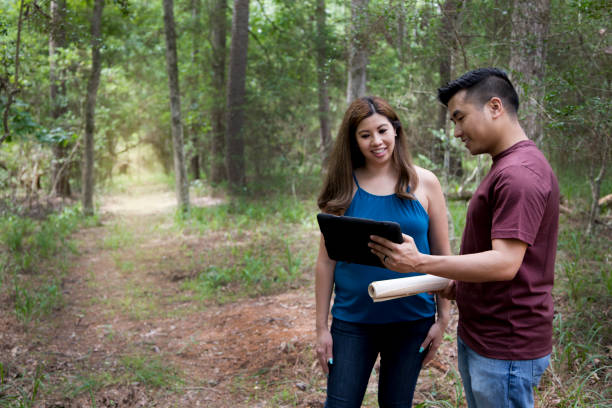 female homeowner discusses home remodel job with contractor or engineer.  contractor wears a t-shirt and jeans. - building contractor engineer digital tablet construction imagens e fotografias de stock