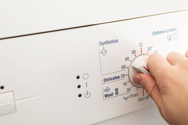 istock The hand turns on the washing machine, presses the mode selection button. 1351316716