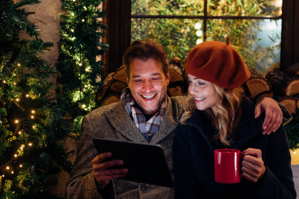 istock Happy Couple Using Digital Tablet while Drinking Mulled Wine in an Outdoor Cafe 1351316795