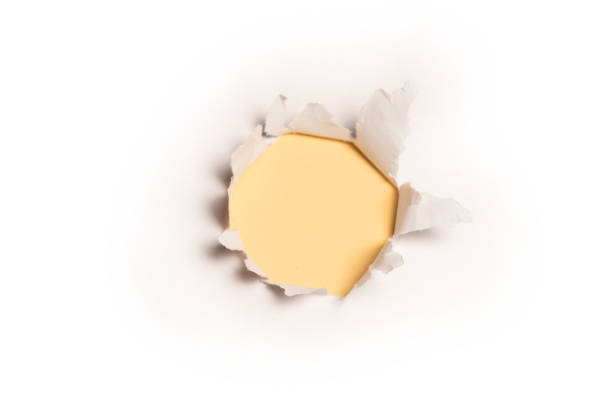 istock A hole in a white paper on a yellow background. 1351317965