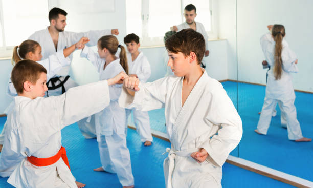 istock Teenagers practicing new karate moves in pairs in class 1351318367
