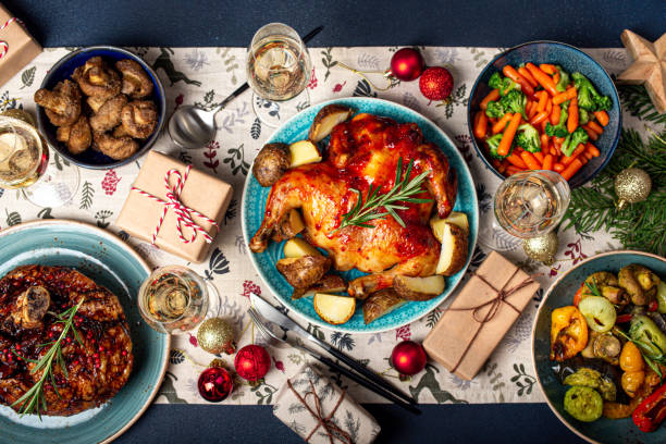 Christmas table top view with food, wine and presents Christmas evening table top view with festive food and sparkling wine glasses, Xmas dinner with assorted delicious meals, wrapped presents and fir tree flat lay winter food top view stock pictures, royalty-free photos & images