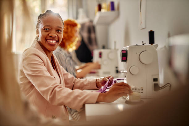 istock Happy african american tailor sewing clothes using a machine 1351320418