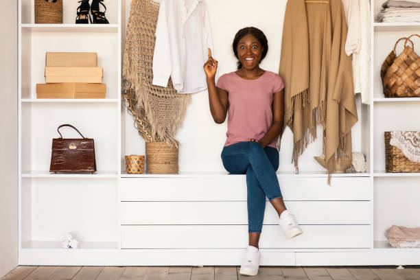 istock Cheerful Black Lady Having Idea Sitting In Wardrobe Room 1351320959