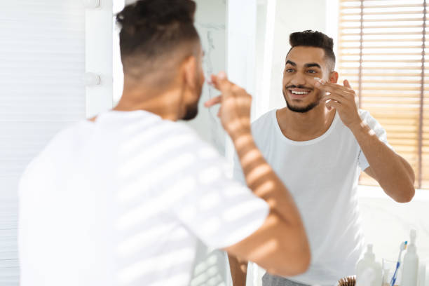 istock Skincare For Men. Handsome Middle Eastern Guy Applying Moisturising Cream On Face 1351322715