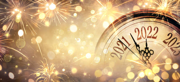 2022 new year - clock and fireworks - countdown to midnight  - abstract defocused background - nieuwjaar stockfoto's en -beelden