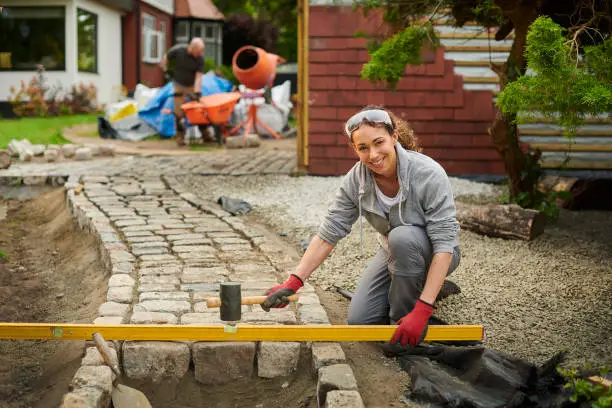 homeowner installing a cobble path