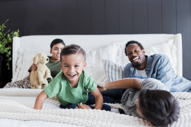 istock Brothers roughhouse as parents relax on bed 1351328641