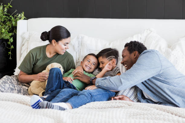 istock Dad tickles young son as family relaxes on bed 1351328643