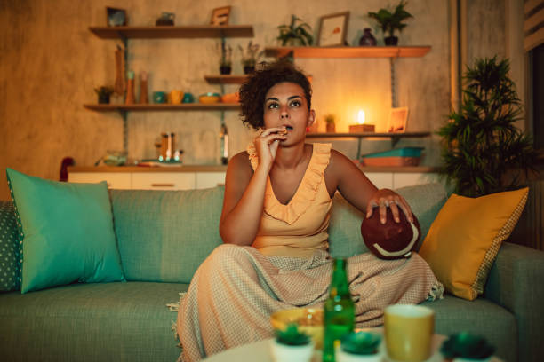 woman with beer watching american football match on tv - american football football food snack imagens e fotografias de stock