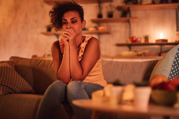 istock Woman sitting alone at home looking sad and distraught 1351330588
