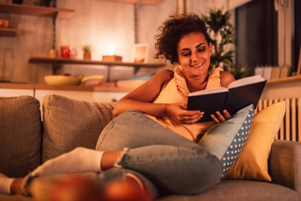 istock Woman lying on sofa and reading book 1351331145