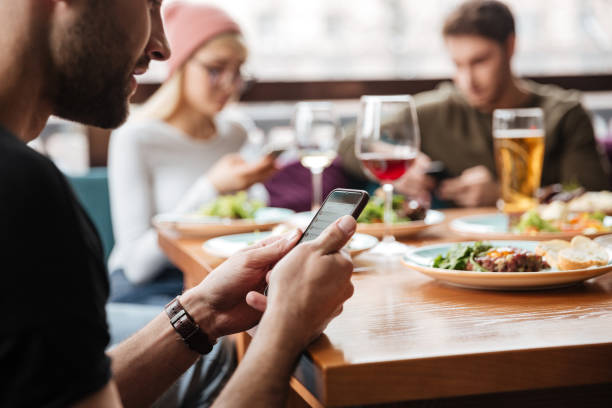 istock Friends sitting in cafe and using mobile phones 1351332347