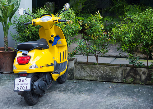 Parked yellow colored Vespa in Bangkok