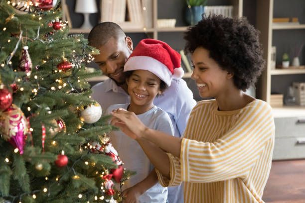 istock Happy african american parents decorating Christmas tree with son. 1351333866