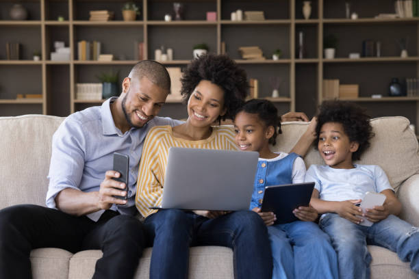 istock Happy african american family using different gadgets. 1351333908