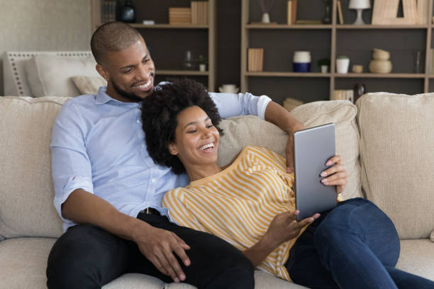 istock Relaxed smiling millennial mixed race couple using tablet. 1351333909