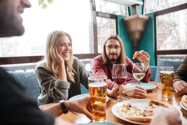 istock Young happy friends in cafe eating pizza while drinking alcohol. 1351333914