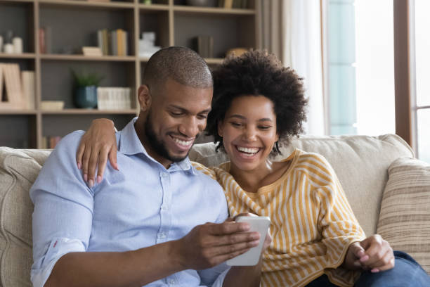 istock Happy beautiful young african american couple using cellphone. 1351333926