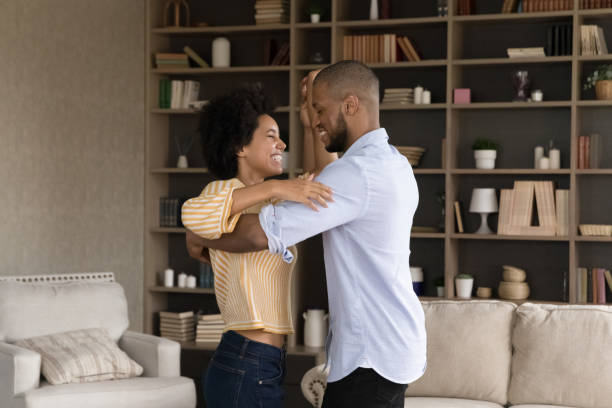 istock Smiling young african couple dancing at home. 1351333936