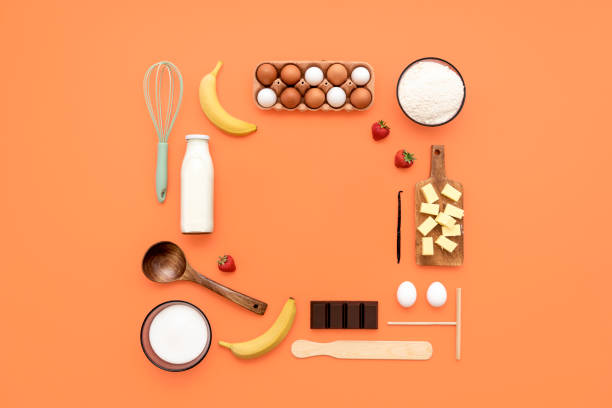 ингредиенты блинчиков и посуду плоско лежат на апельсиновом столе. - dairy product фотографии стоковые фото и изображения