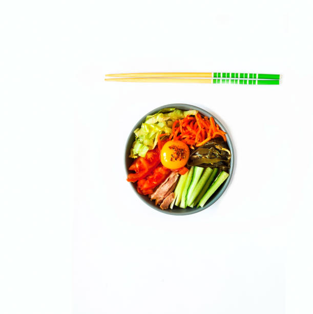 Traditional dish of Korean cuisine. Bibimbap with beef, vegetables and egg on white isolated background. Creative copy space