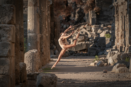 Beautiful ballerine jumping and dancing in ancient City.