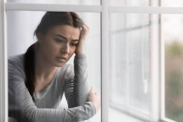 istock Unhappy sad european young lady suffering from depression, stress and mental problems near window with rain drops 1351336621