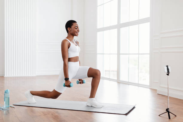 istock Black woman doing forward lunges in front of smartphone 1351337394