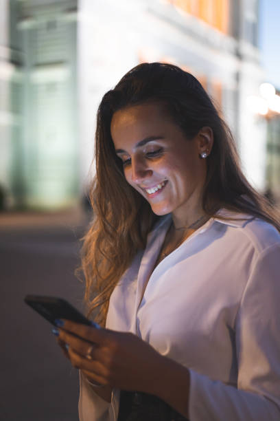 istock Young caucasian woman using a smartphone at night in Madrid, Spain. 1351337718