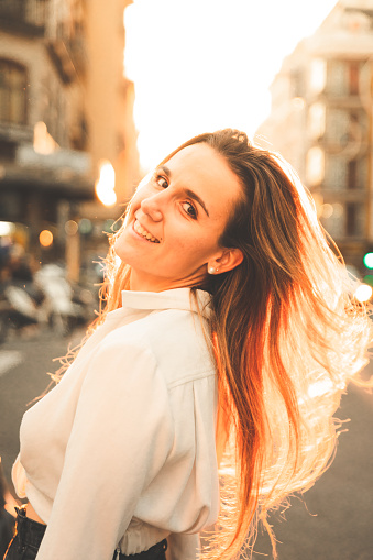 Young caucasian woman walking through Madrid during sunset hour, Spain.