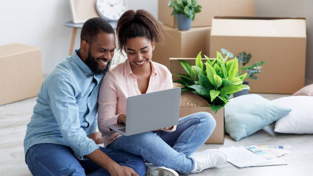 smiling millennial african american wife showing to husband laptop with new room design - Second Mortgage with Bad Credit - Be Approved