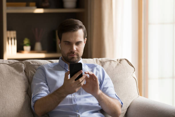 istock Happy young handsome man in earbuds using cellphone. 1351342474