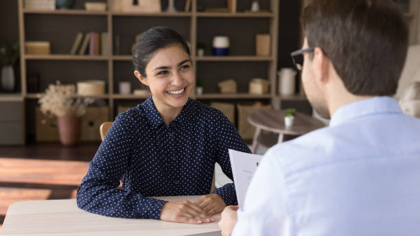 Happy Indian job seeker holding interview with hr manager. Happy attractive millennial Indian female job seeker holding interview with male leader, making good first impression at meeting, discussing working offer in modern office, employment concept. hire job search job people stock pictures, royalty-free photos & images