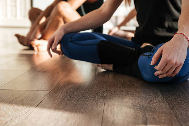 istock Woman sitting and practicing yoga in group at studio 1351342522