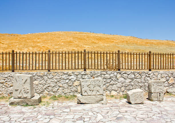 Malatya, Turkey - July 13, 2021:Arslantepe Tumulus view, people visit the tumulus which is unesco world heritage site. Civilization that was formed 5000 years ago. Arslantepe Mound (Arslantepe Hoyugu). Statues at the entrance of the historical Arslantepe (4000 BCE) settlement in Malatya, Turkey. lion sculp statue view.