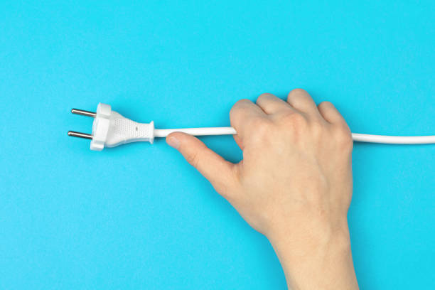 istock Hand with electrical power cable with EU plug on a bright blue background, flat lay, top view and copy space photo 1351344806