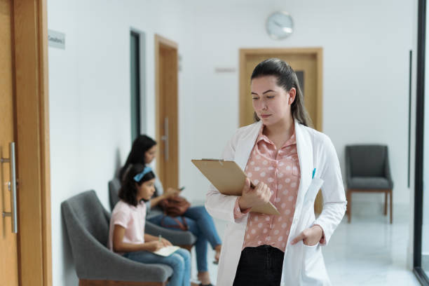 istock Female psychologist standing and looking at clipboard 1351346140