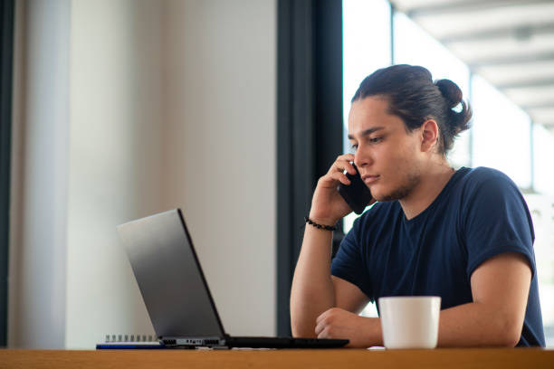 istock Young man  talking on the phone about his work 1351346594