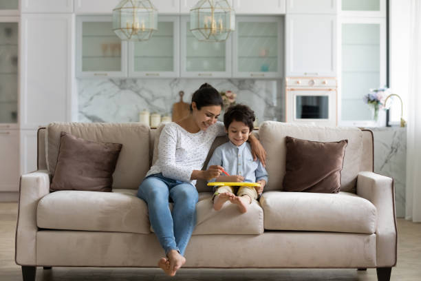 istock Happy young indian mother drawing on tablet with small kid. 1351347315