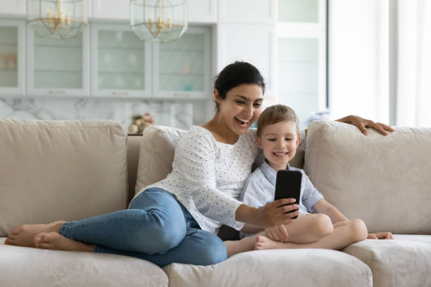 istock Happy bonding mixed race family using cellphone at home. 1351347354